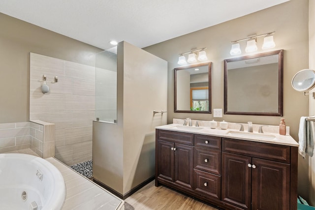 13048 Jay St NW, Coon Rapids, MN 55448 - bathroom with a jetted tub, double vanity, a walk in shower, and wood finished floors