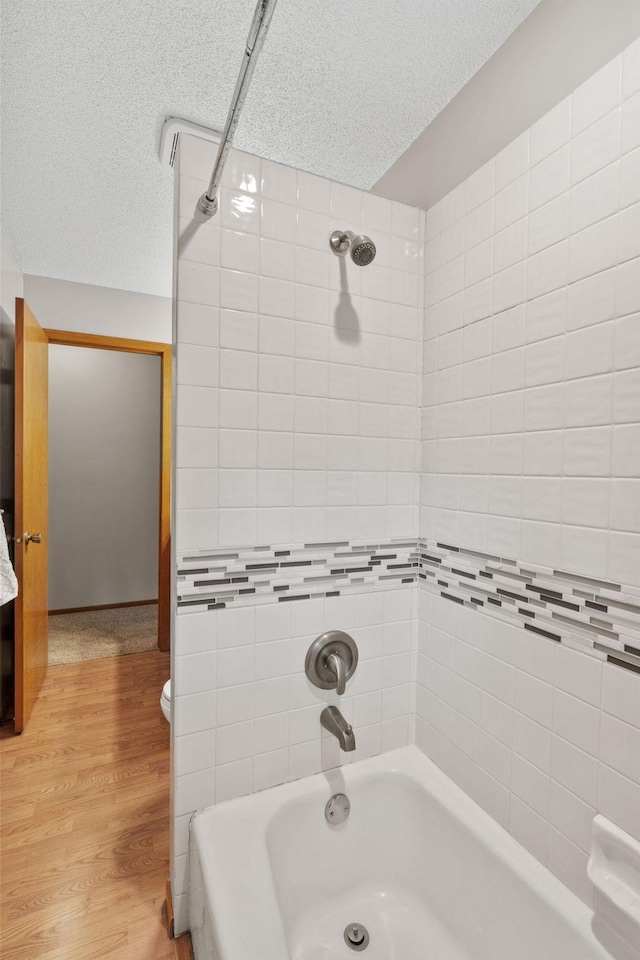 13048 Jay St NW, Coon Rapids, MN 55448 - full bathroom featuring  shower combination, a textured ceiling, and wood finished floors