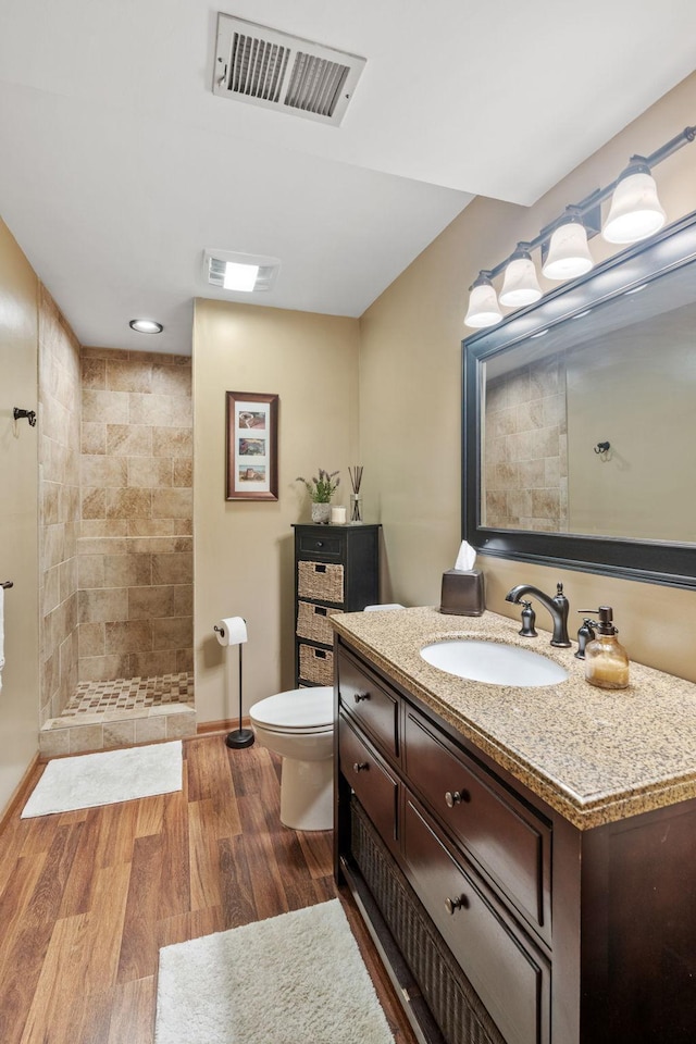 13048 Jay St NW, Coon Rapids, MN 55448 - full bath featuring a tile shower, vanity, and wood finished floors