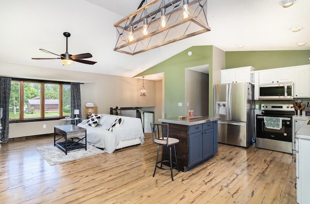 204 Sidney St E, Morristown, MN 55052 - kitchen with appliances with stainless steel finishes, white cabinetry, light wood-type flooring, ceiling fan, and high vaulted ceiling