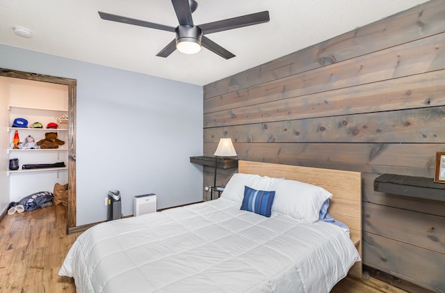 204 Sidney St E, Morristown, MN 55052 - bedroom with wood finished floors, wood walls, and a ceiling fan