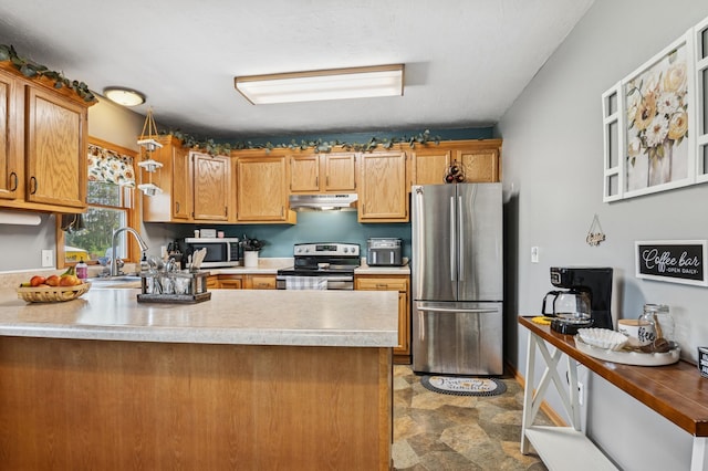 2796 269th Ave NE, Isanti, MN 55040 - kitchen featuring appliances with stainless steel finishes, under cabinet range hood, stone finish floors, a peninsula, and light countertops