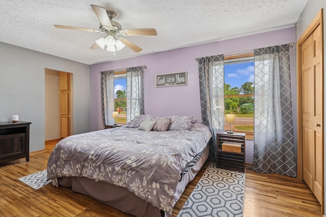 2796 269th Ave NE, Isanti, MN 55040 - bedroom with light wood-style floors, a textured ceiling, and a ceiling fan