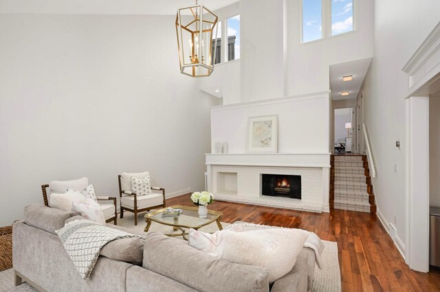 5713 Duncan Ln, Edina, MN 55436 - living room with a brick fireplace, a chandelier, a high ceiling, stairs, and wood finished floors
