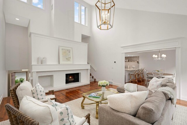 5713 Duncan Ln, Edina, MN 55436 - living area featuring a chandelier, a high ceiling, wood finished floors, healthy amount of natural light, and a brick fireplace