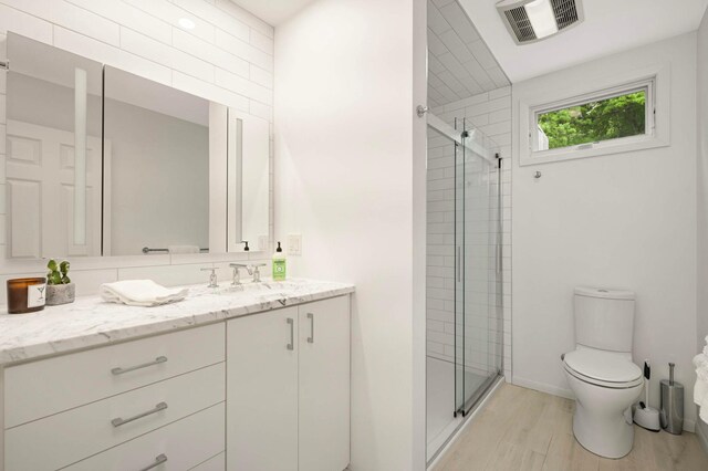 5713 Duncan Ln, Edina, MN 55436 - bathroom featuring vanity, a stall shower, and wood finished floors