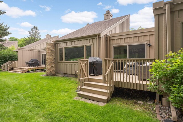 5713 Duncan Ln, Edina, MN 55436 - back of house featuring a deck, a shingled roof, a lawn, board and batten siding, and a chimney