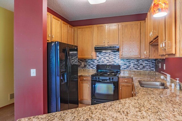 1152 Crystal Pl W, Chaska, MN 55318 - kitchen featuring black appliances, under cabinet range hood, tasteful backsplash, light stone counters, and a textured ceiling