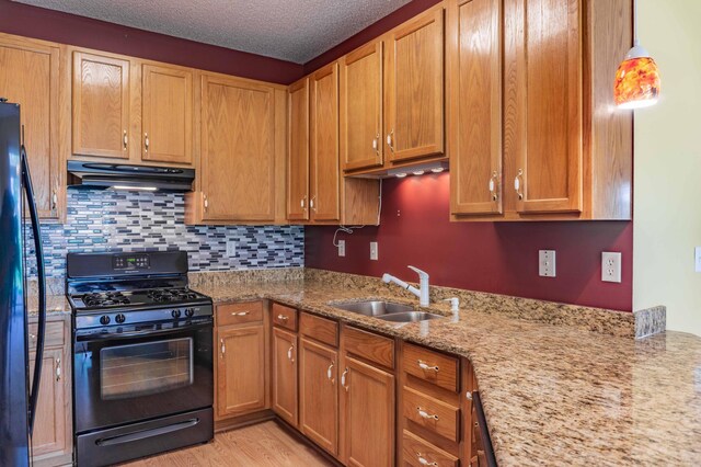 1152 Crystal Pl W, Chaska, MN 55318 - kitchen with black range with gas stovetop, extractor fan, light wood-style flooring, fridge, and light stone counters