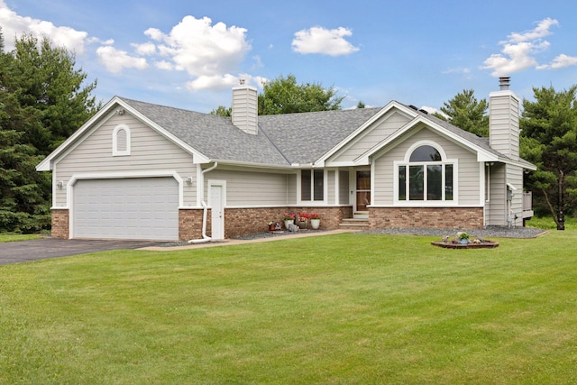2771 County Line Ave, Osceola, WI 54020 - view of front facade featuring brick siding, a chimney, asphalt driveway, and an attached garage