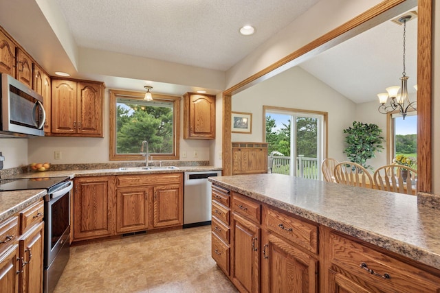 2771 County Line Ave, Osceola, WI 54020 - kitchen featuring appliances with stainless steel finishes, brown cabinetry, a chandelier, decorative light fixtures, and lofted ceiling