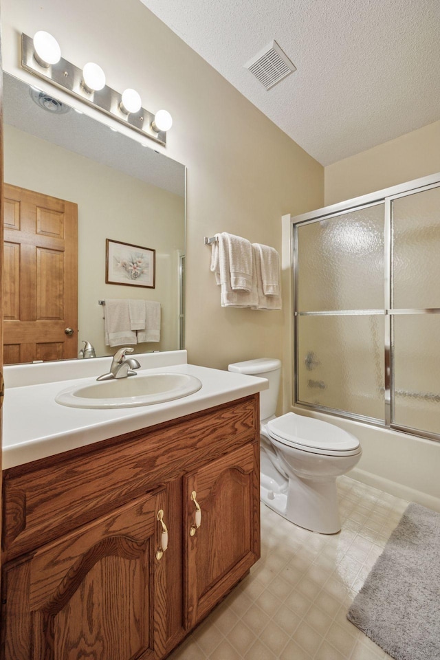2771 County Line Ave, Osceola, WI 54020 - full bathroom featuring vanity, combined bath / shower with glass door, tile patterned floors, and a textured ceiling