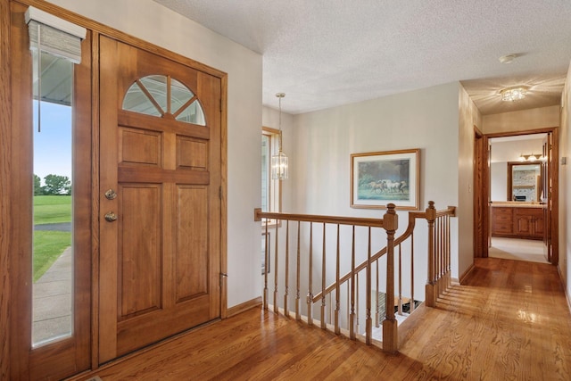 2771 County Line Ave, Osceola, WI 54020 - entrance foyer featuring wood finished floors, a textured ceiling, and a chandelier