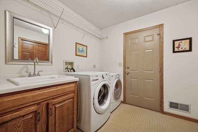 2771 County Line Ave, Osceola, WI 54020 - laundry room with separate washer and dryer, cabinet space, light tile patterned floors, and a textured ceiling