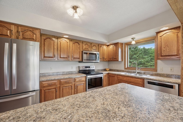 2771 County Line Ave, Osceola, WI 54020 - kitchen featuring appliances with stainless steel finishes, brown cabinets, and a textured ceiling