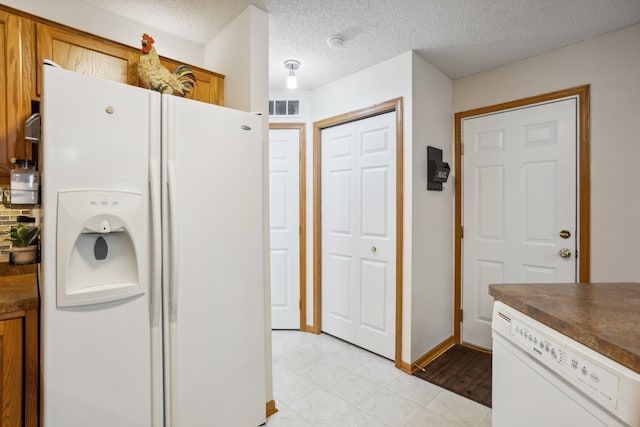 3307 Coleshire Path Unit 14, Rosemount, MN 55068 - kitchen featuring white appliances, dark countertops, a textured ceiling, and brown cabinets