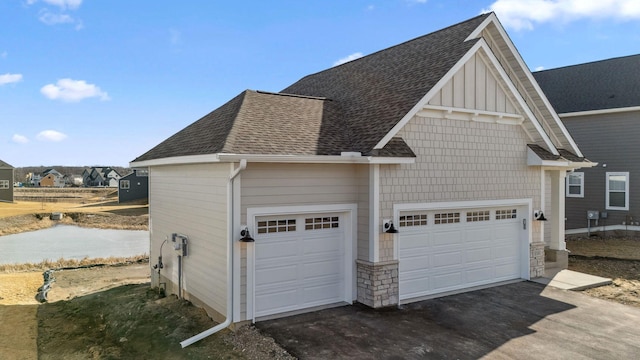 10180 Shadyview Ln N, Maple Grove, MN 55311 - view of side of property with a shingled roof, a garage, driveway, and stone siding