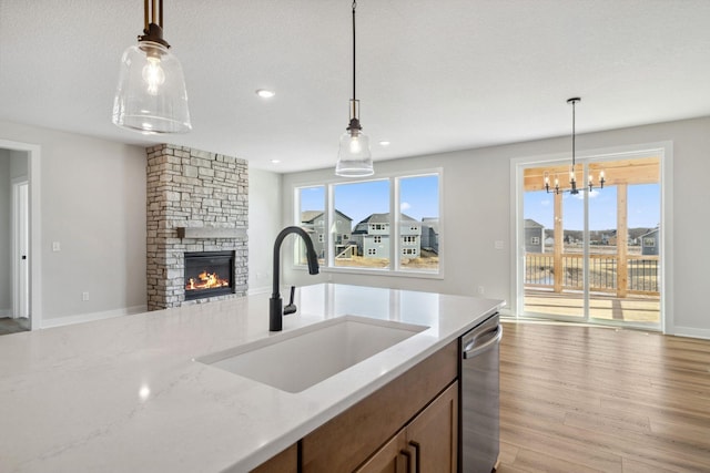 10180 Shadyview Ln N, Maple Grove, MN 55311 - kitchen with dishwasher, open floor plan, a stone fireplace, light wood-style flooring, and hanging light fixtures