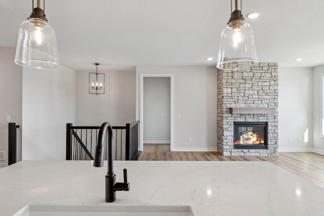 10180 Shadyview Ln N, Maple Grove, MN 55311 - unfurnished dining area with wood finished floors, a textured ceiling, a chandelier, a stone fireplace, and recessed lighting