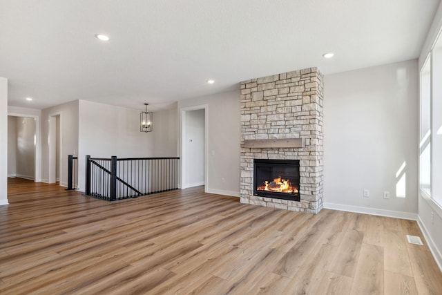 10180 Shadyview Ln N, Maple Grove, MN 55311 - unfurnished living room featuring light wood-style floors, a fireplace, recessed lighting, and a chandelier