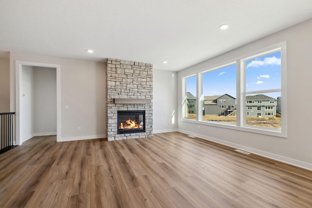 10180 Shadyview Ln N, Maple Grove, MN 55311 - unfurnished living room with wood finished floors, a stone fireplace, and recessed lighting