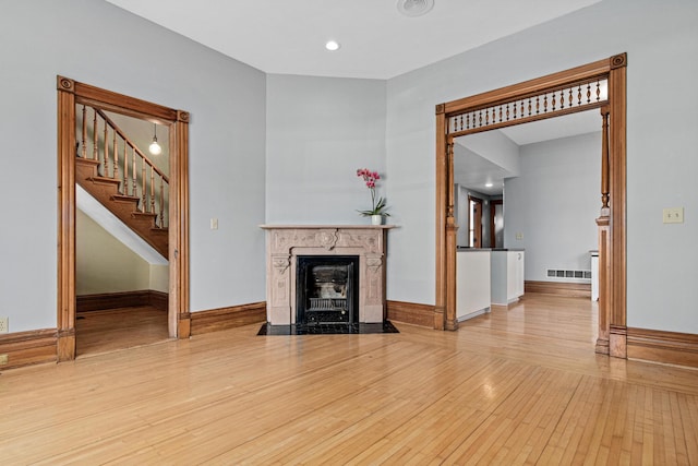 1813 11th Ave S, Minneapolis, MN 55404 - unfurnished living room with wood-type flooring, stairway, a fireplace, and recessed lighting