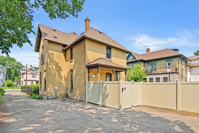 1813 11th Ave S, Minneapolis, MN 55404 - rear view of property with brick siding, a gate, a chimney, and a residential view