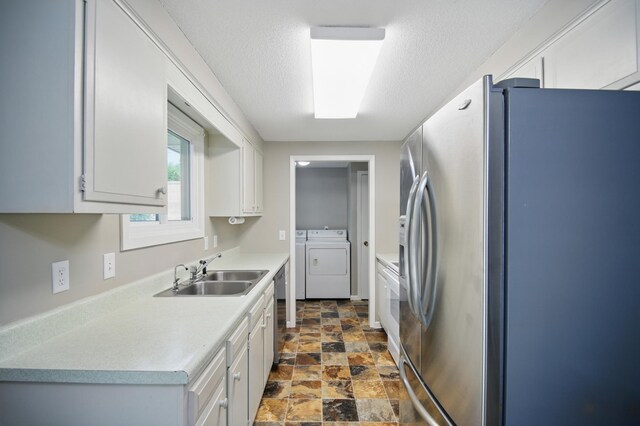 455 Sylvan St, Owatonna, MN 55060 - kitchen with appliances with stainless steel finishes, stone finish floors, light countertops, washer and dryer, and white cabinetry