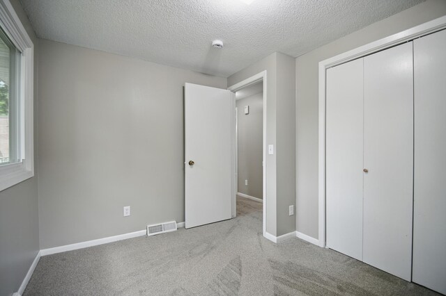 455 Sylvan St, Owatonna, MN 55060 - unfurnished bedroom with carpet flooring, a textured ceiling, and a closet