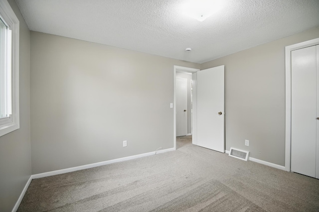 455 Sylvan St, Owatonna, MN 55060 - unfurnished bedroom featuring carpet floors and a textured ceiling