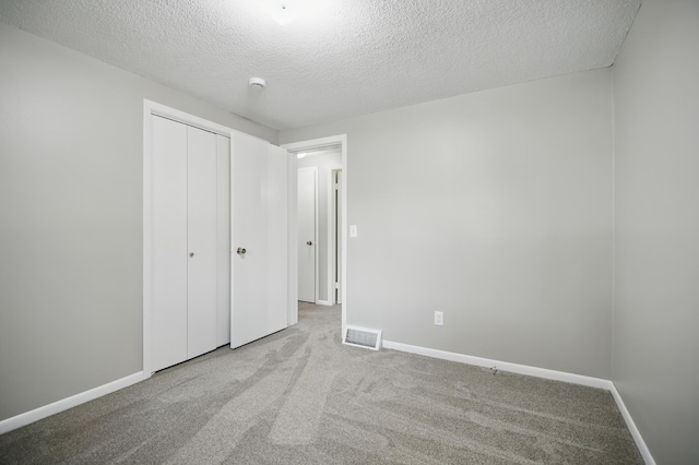 455 Sylvan St, Owatonna, MN 55060 - unfurnished bedroom featuring carpet, a textured ceiling, and a closet