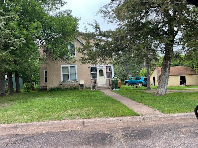 205 1st Ave SE, Pine City, MN 55063 - view of front facade with stucco siding, entry steps, and a front yard