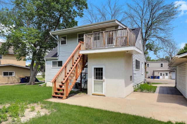 1115 3rd St NW, Faribault, MN 55021 - back of house with stairs, a lawn, a balcony, and stucco siding