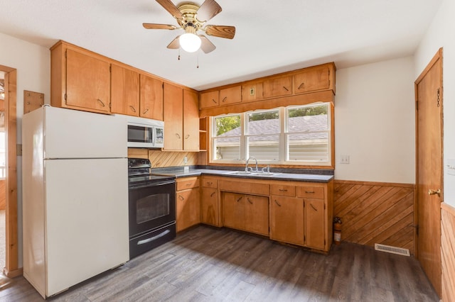 1115 3rd St NW, Faribault, MN 55021 - kitchen with white appliances, dark wood-style floors, a wainscoted wall, ceiling fan, and brown cabinets