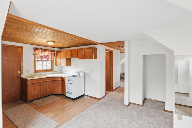 1115 3rd St NW, Faribault, MN 55021 - kitchen featuring white gas stove, light countertops, brown cabinetry, light wood finished floors, and wooden ceiling