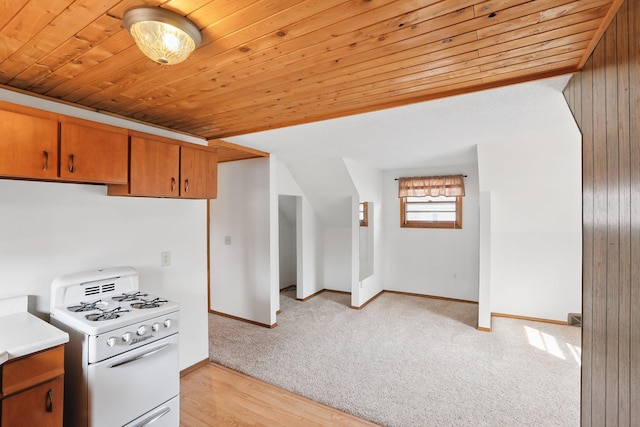 1115 3rd St NW, Faribault, MN 55021 - kitchen with white range with gas stovetop, wood ceiling, light countertops, brown cabinetry, and light carpet