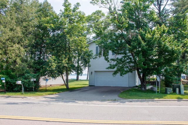 29042 County Road 4, Breezy Point, MN 56472 - view of property hidden behind natural elements featuring a garage, asphalt driveway, and a front lawn