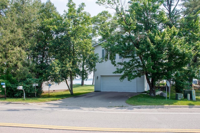 29042 County Road 4, Breezy Point, MN 56472 - view of property hidden behind natural elements with a garage, asphalt driveway, and a front yard