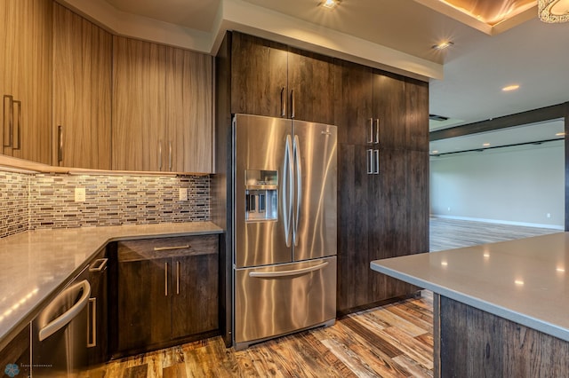 3405 4th St E, West Fargo, ND 58078 - kitchen with stainless steel fridge, wood finished floors, decorative backsplash, dark brown cabinetry, and modern cabinets