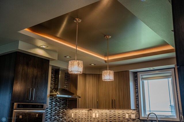 3405 4th St E, West Fargo, ND 58078 - kitchen with wall chimney exhaust hood, stainless steel oven, a raised ceiling, and backsplash