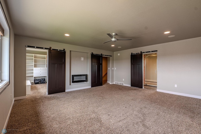 3405 4th St E, West Fargo, ND 58078 - unfurnished bedroom featuring a barn door, a walk in closet, carpet, recessed lighting, and a closet