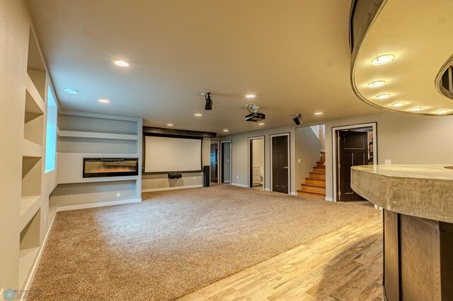 3405 4th St E, West Fargo, ND 58078 - unfurnished living room featuring stairs, recessed lighting, a glass covered fireplace, carpet flooring, and wood finished floors