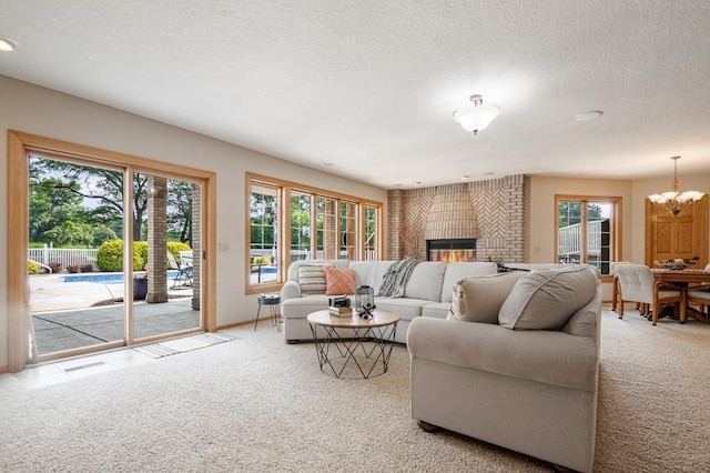 13907 Washington St NE, Ham Lake, MN 55304 - living area with carpet, a chandelier, a fireplace, and a textured ceiling