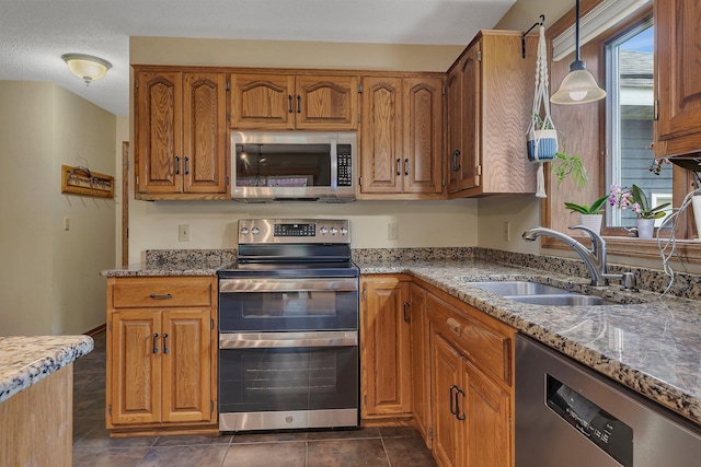 2708 Tranquility Dr, Saint Cloud, MN 56301 - kitchen with appliances with stainless steel finishes, brown cabinetry, and stone counters