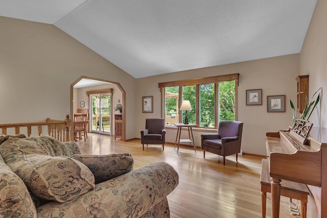2708 Tranquility Dr, Saint Cloud, MN 56301 - living room featuring arched walkways, lofted ceiling, healthy amount of natural light, and light wood-style floors