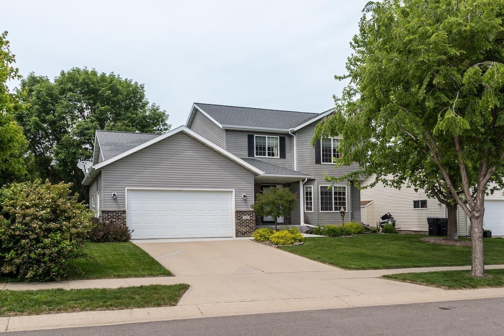 5241 Lexington Pl NW, Rochester, MN 55901 - view of front of property featuring an attached garage, brick siding, a front lawn, and driveway