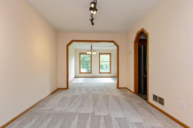 14500 Raleigh Ave, Savage, MN 55378 - spare room with a chandelier, arched walkways, and carpet