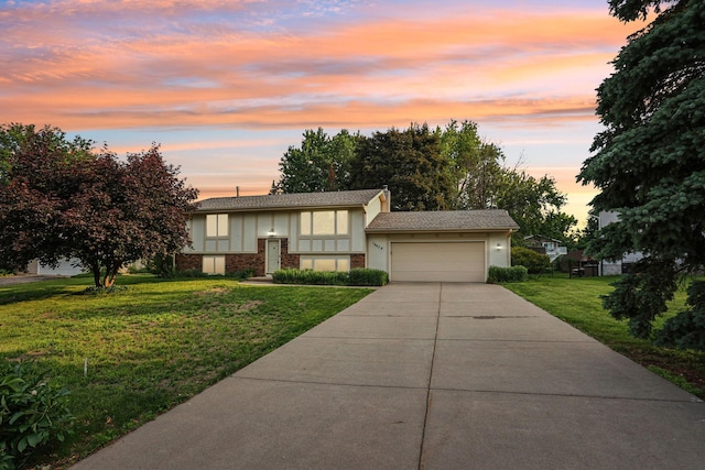 16679 Dublin Rd SE, Prior Lake, MN 55372 - bi-level home featuring an attached garage, concrete driveway, a front lawn, stucco siding, and brick siding