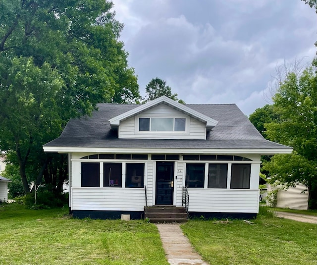 60 Main St, Kimball, MN 55353 - view of front of home with a sunroom, a front yard, a shingled roof, and entry steps