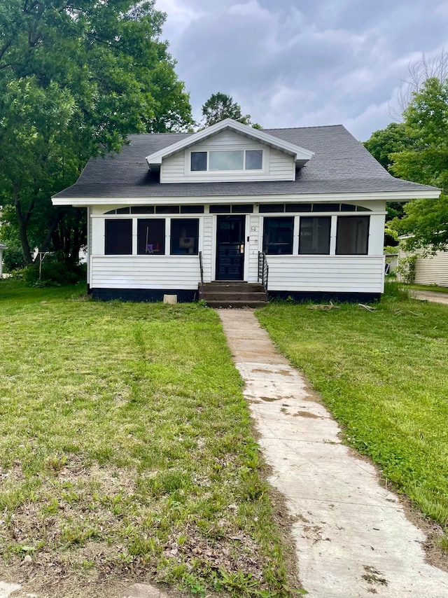 60 Main St, Kimball, MN 55353 - bungalow-style home with a sunroom, a front lawn, and roof with shingles